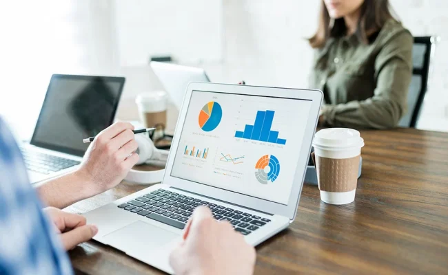 businessman-analyzing-graphs-laptop-while-working-with-colleague-office businessman-analyzing-graphs-laptop-while-working-with-colleague-office
